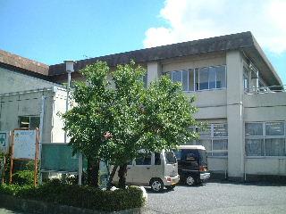 緑の木々の向こうに見える幸松第二公民館の外観の写真（「幸松第二公民館」のページへリンク）